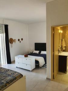een slaapkamer met een bed en een badkamer met een wastafel bij Beira Mar Apartment in Portimão