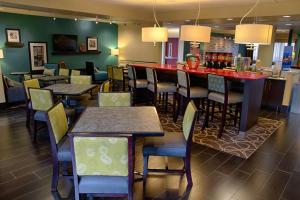 a restaurant with tables and chairs and a bar at Hampton Inn Dayton/Huber Heights in Huber Heights