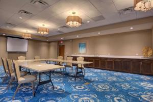 une salle de conférence avec une table, des chaises et un podium dans l'établissement Hampton Inn & Suites by Hilton Tampa Busch Gardens Area, à Tampa