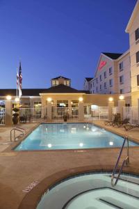 a pool in front of a hotel at night at Hilton Garden Inn Clovis in Clovis