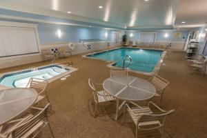 una gran piscina con mesa y sillas y un asterisco en Hampton Inn Bangor en Bangor