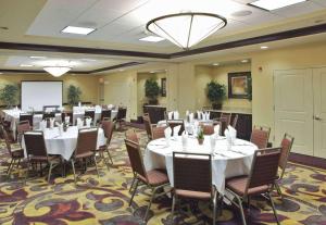 Hilton Garden Inn Clovis في كلوفيس: قاعة اجتماعات مع طاولات وكراسي وشاشة عرض