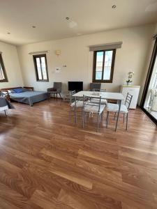 Extremely comfy 10min walk to Beach & Town في لارنكا: غرفة معيشة مع أرضية خشبية وطاولة وكراسي