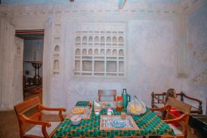 Habitación con mesa, sillas y ventana en Amu House en Lamu