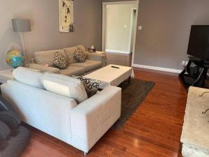 a living room with a white couch and a tv at Lovely house in a nice community in Toronto