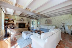 a living room with white furniture and a fireplace at Le Moulin de Bafave in Périssac
