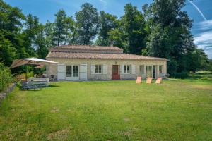 a small house with an umbrella in a yard at Le Moulin de Bafave in Périssac