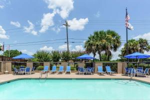 a swimming pool with chairs and umbrellas at Hampton Inn Biloxi-Ocean Springs in Biloxi