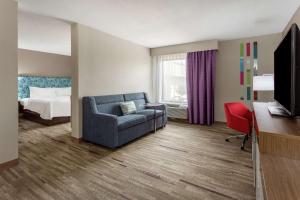 Habitación de hotel con sofá y cama en Hampton Inn Biloxi-Ocean Springs, en Biloxi