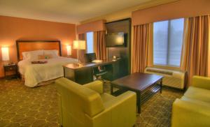 a hotel room with a bed and a desk and chairs at Hampton Inn and Suites Parsippany/North in Parsippany