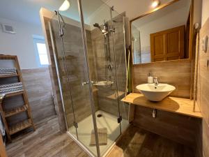 a bathroom with a glass shower and a sink at Apartment Brusinka in Kašperské Hory