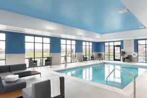 a pool in a hotel room with blue walls and windows at Hampton Inn O'Fallon, Il in O'Fallon