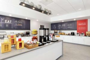 a kitchen with white cabinets and a counter with food at Hampton Inn O'Fallon, Il in O'Fallon