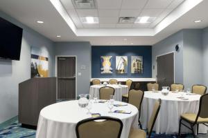 a conference room with tables and chairs and a tv at Hampton Inn O'Fallon, Il in O'Fallon
