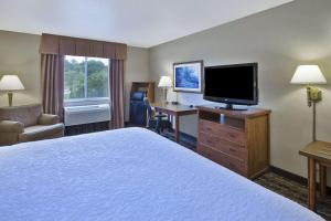 a hotel room with a bed and a flat screen tv at Hampton Inn Pittsburgh Area-Beaver Valley-Center Township in Monaca