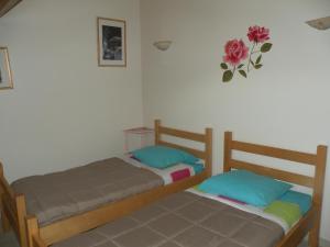 - 2 lits dans une chambre avec une fleur sur le mur dans l'établissement GITE LES 1000 FLEURS, à Souteyros