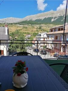 a vase with flowers on a table with a view at Nicola's house in Campo di Giove
