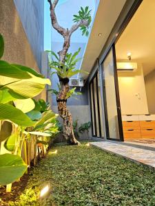 an indoor garden with a tree in the middle of a building at Rania Guest House in Salakan