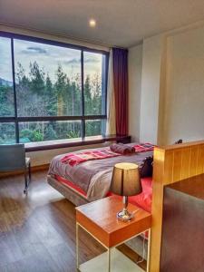 a bedroom with a bed and a large window at Hill Myna Condo by Bcare - Two Bedrooms in Ban Thalat Choeng Thale