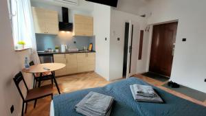 a bedroom with a bed and a table and a kitchen at Studio Dąbrowa Żeromskiego in Dąbrowa Górnicza