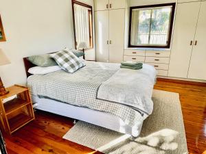 a bedroom with a bed and a window at Bello Cottage in Bellingen