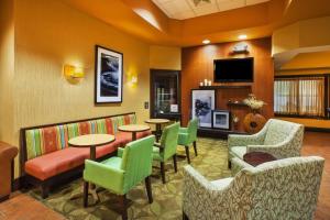 a waiting room with tables and chairs and a flat screen tv at Hampton Inn Gaylord in Gaylord