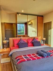 a bedroom with a large bed with red and blue pillows at Hill Myna Condo by Bcare - Two Bedrooms in Ban Thalat Choeng Thale +53 photos
