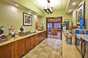a large kitchen with wooden cabinets and green walls at Hampton Inn Gaylord in Gaylord