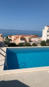 a blue swimming pool with a view of the ocean at Luxury Apartments Villa Lenka in Podstrana