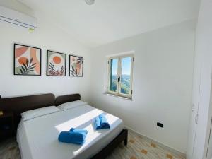 een slaapkamer met een bed met blauwe handdoeken bij Marasusa Apartments Tramontana in Parghelia