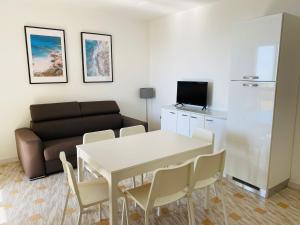 een woonkamer met een witte tafel en een bank bij Marasusa Apartments Tramontana in Parghelia