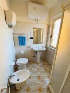 een badkamer met 2 toiletten en een wastafel bij Marasusa Apartments Tramontana in Parghelia