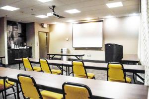 una sala de conferencias con mesas, sillas amarillas y una pantalla en Hampton Inn & Suites Richmond Glenside, en Richmond