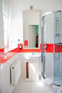 La salle de bains est pourvue d'un lavabo, d'une douche et d'un miroir. dans l'établissement Kuźnia Pałacowa, à Korczew