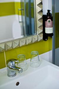 a bathroom sink with two glasses and a bottle of wine at Kuźnia Pałacowa in Korczew