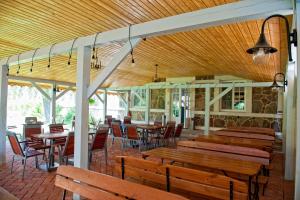 a restaurant with wooden benches and tables and chairs at Kuźnia Pałacowa in Korczew