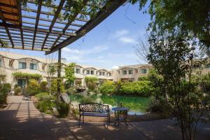 美國峽谷的住宿－DoubleTree by Hilton Napa Valley - American Canyon，一座花园,在一座建筑前设有长凳和喷泉