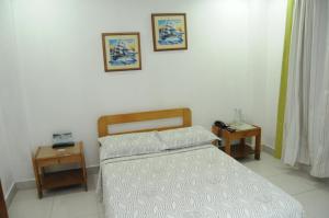a bedroom with a bed and two night stands at Hotel Veleros Cartagena in Cartagena de Indias