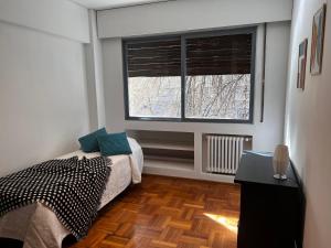 a bedroom with a bed and a large window at Departamento moderno calle España! in Mendoza