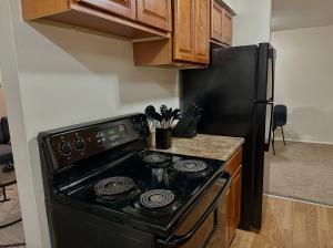 a kitchen with a black stove and a refrigerator at Cozy Apartment in Frederick in Frederick