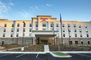 um grande edifício com uma bandeira em frente em Hampton Inn Black Mountain em Black Mountain