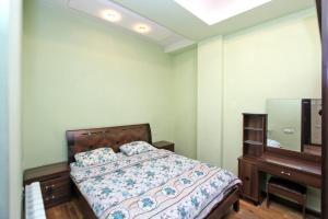 LUXURY Apartment in Yerevan, CENTRE في يريفان: غرفة نوم بسرير وخزانة ومرآة