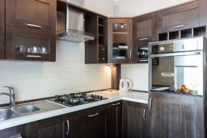 a kitchen with wooden cabinets and a stove top oven at Apartament Abrahama in Gdynia +7 photos