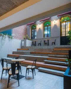 a waiting area with chairs and tables and windows at ANDÉN FMA-Coliving in Salta