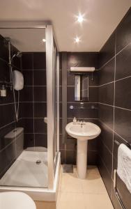 uma casa de banho com um lavatório, um chuveiro e um WC. em The Rodney Hotel em Bristol