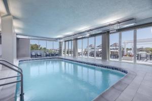 a large swimming pool in a building with windows at Coast Rehoboth Beach, Tapestry Collection By Hilton in Rehoboth Beach