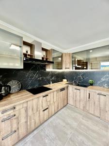uma cozinha com armários de madeira e uma parede preta em À 10 min du centre de strasbourg appartement netflix em Estrasburgo