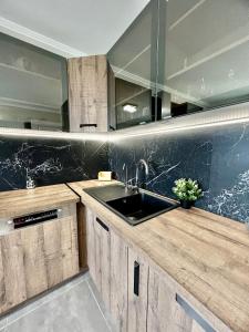 uma cozinha com armários de madeira e um lavatório em À 10 min du centre de strasbourg appartement netflix em Estrasburgo