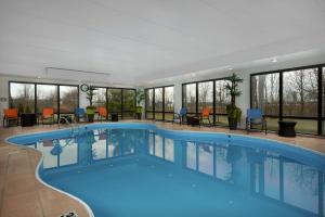 una piscina en un hotel con mesas y sillas en Hampton Inn Youngstown West, en Mineral Ridge