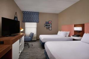 a hotel room with two beds and a flat screen tv at Hampton Inn Youngstown West in Mineral Ridge